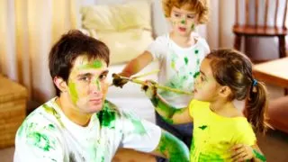 how many kids can you babysit without a license - two young children painting their male babysitter in green paint.